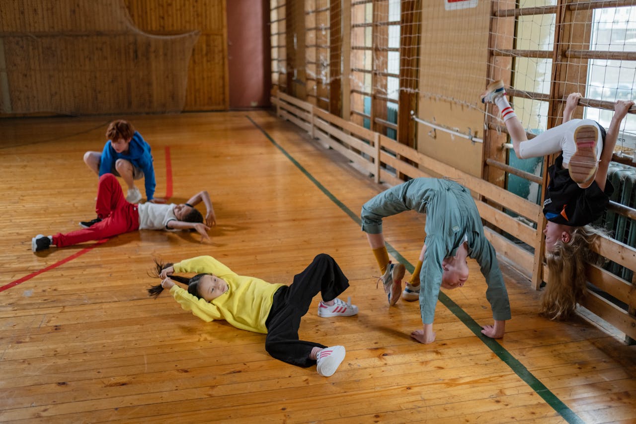 Children playing in a gym, engaging in acrobatic exercises with friends. Indoor fun and physical education.